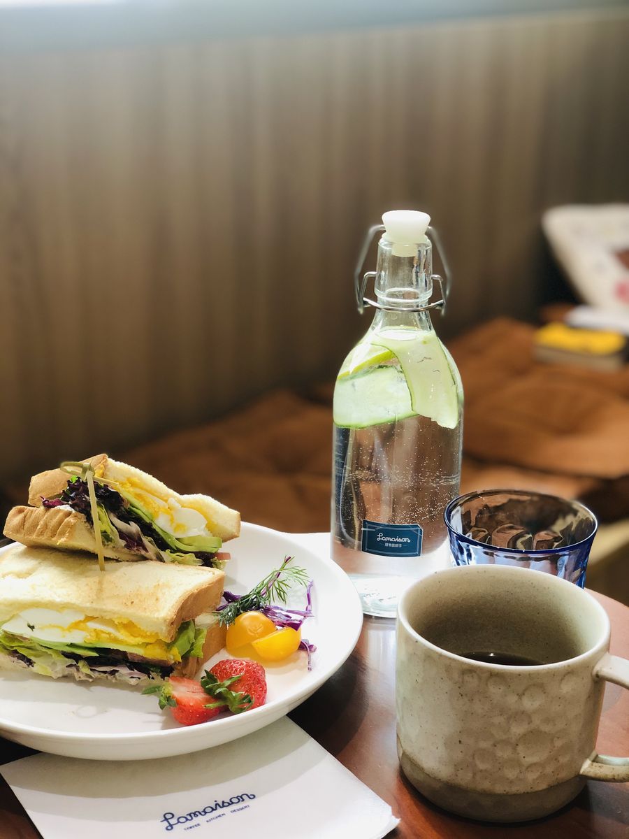 群青咖啡馆的三明治套餐，配气泡水与手冲咖啡，摆在全麦吐司与新鲜蔬果盘中